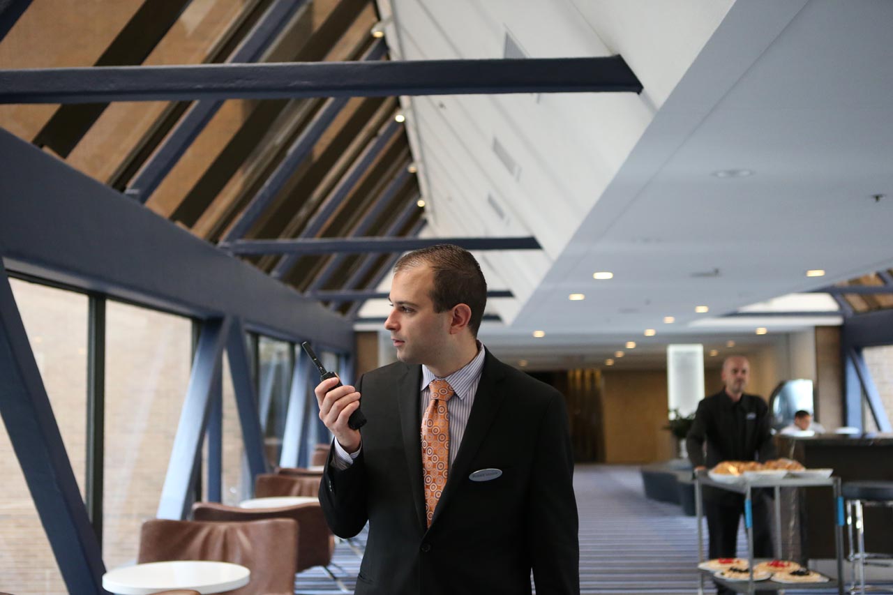 man in suit holding a walkie talkie
