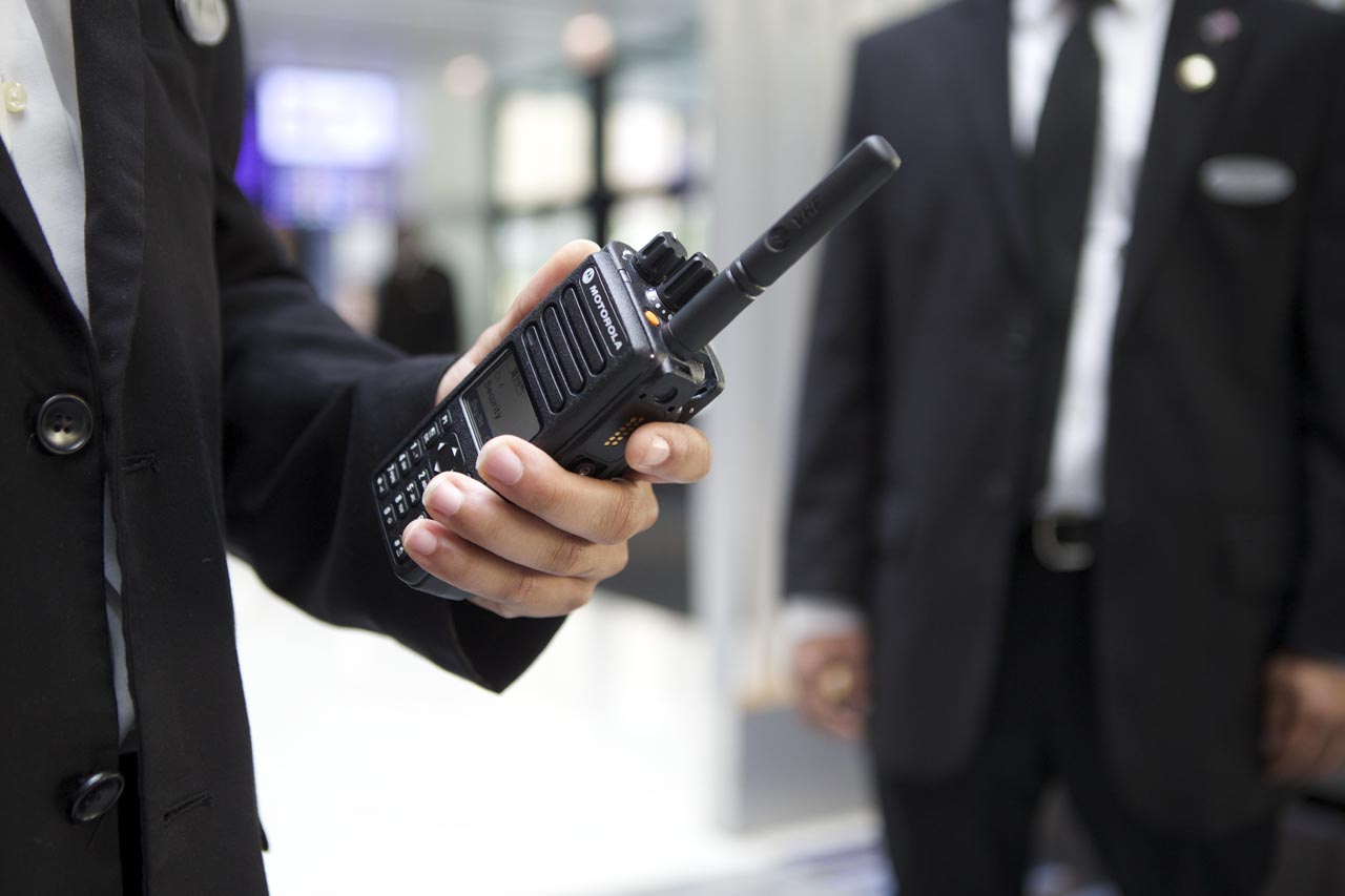 man in suit holding a walkie talkie