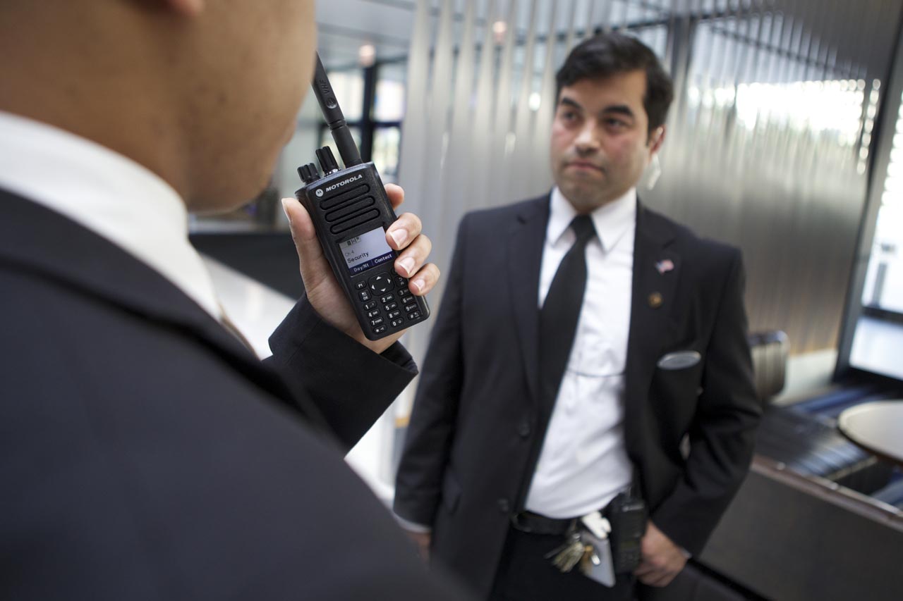 man in suit holding a walkie talkie